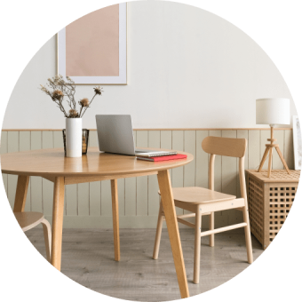 Modern dining table set with two chairs, accented by a vase and laptop