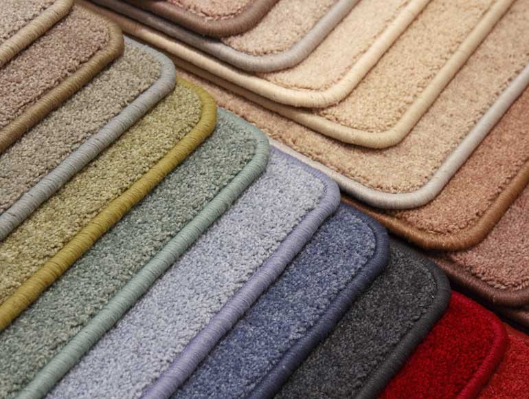Finished carpet edges in different colours showing matching yarn bindings