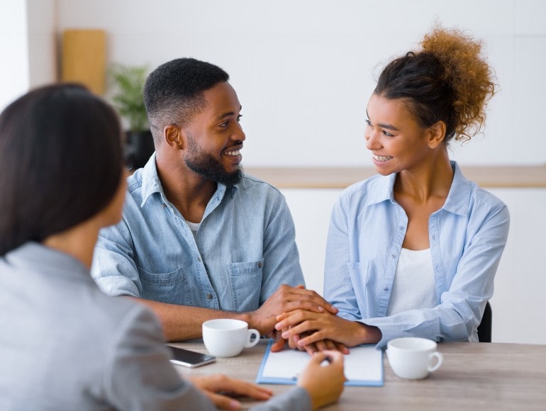 Happy customers completing a flexible financing application with staff assistance