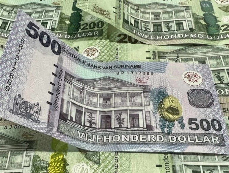 SRD 500 banknote resting on a pile of SRD 200 banknotes
