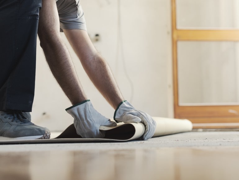 Flooring technician removing old vinyl flooring for replacement