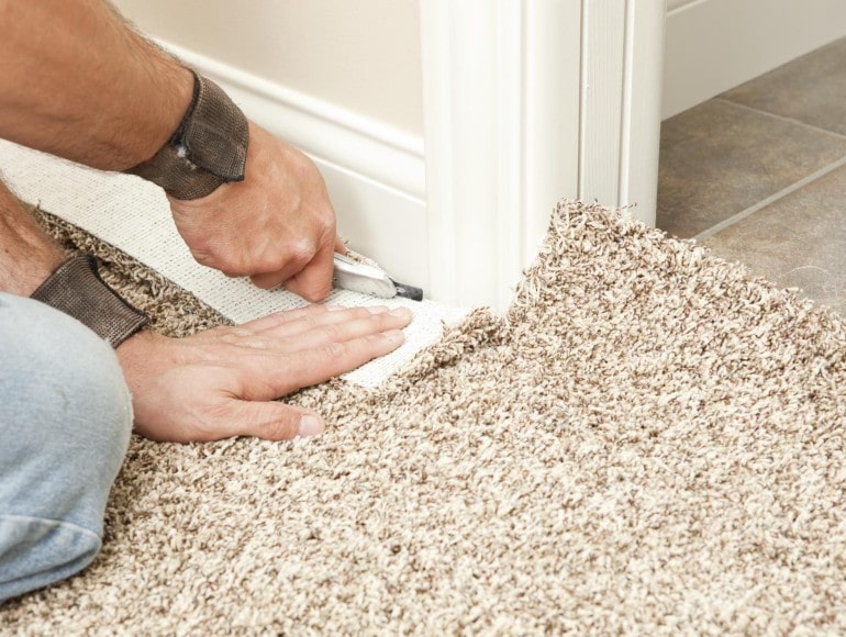 Flooring technician carefully installing a new carpet
